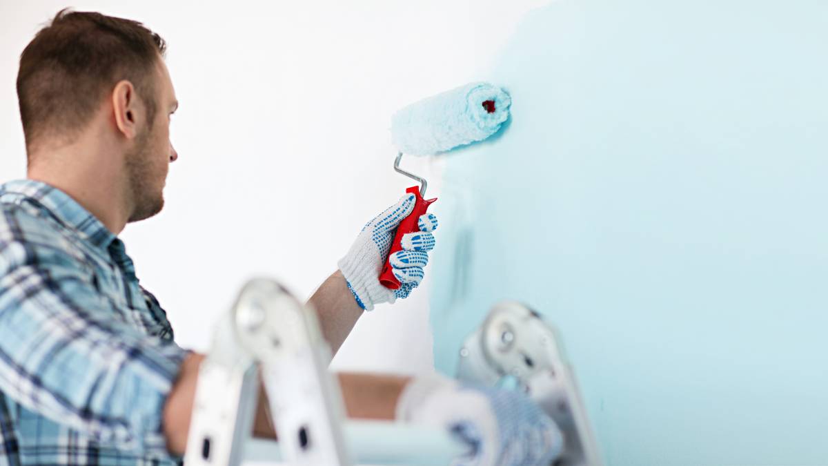 man painting apartment wall