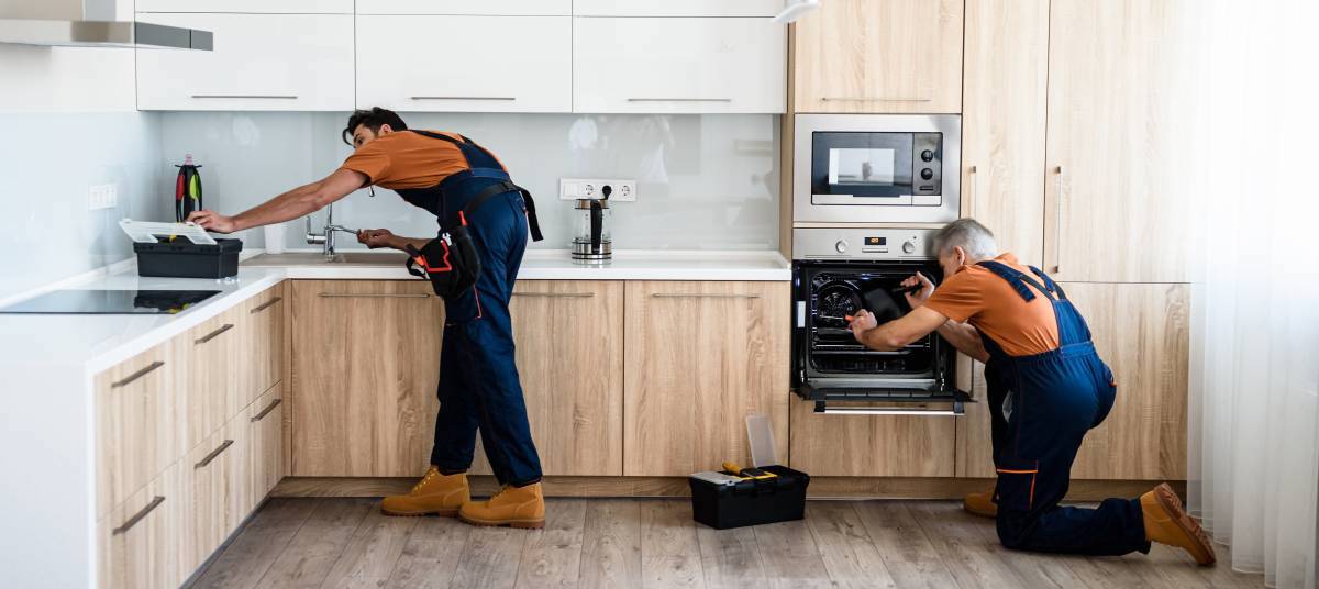two handymen working in a kitchen