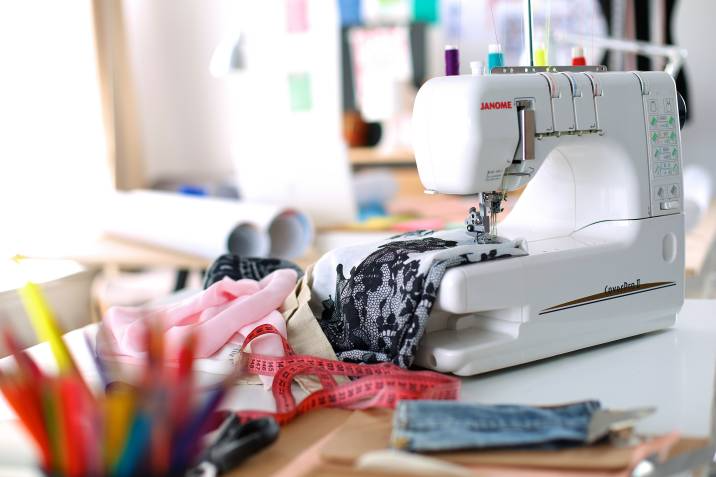 sewing machine on a desk with fabric and measuring tape