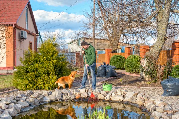 man cleaning up garden for spring