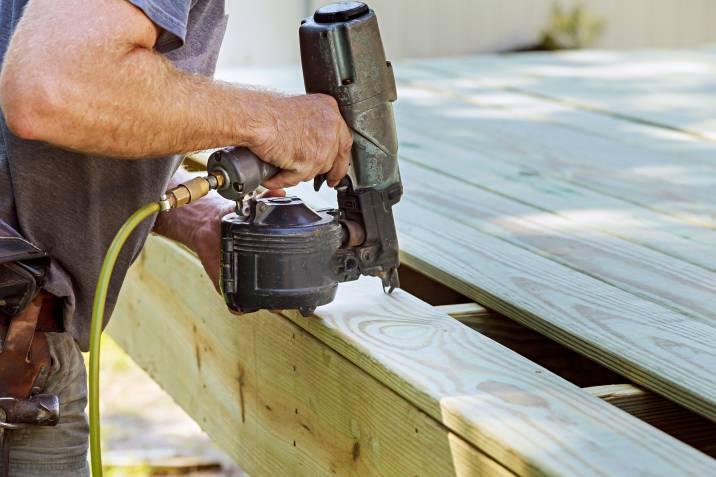 a man installing a wooden deck