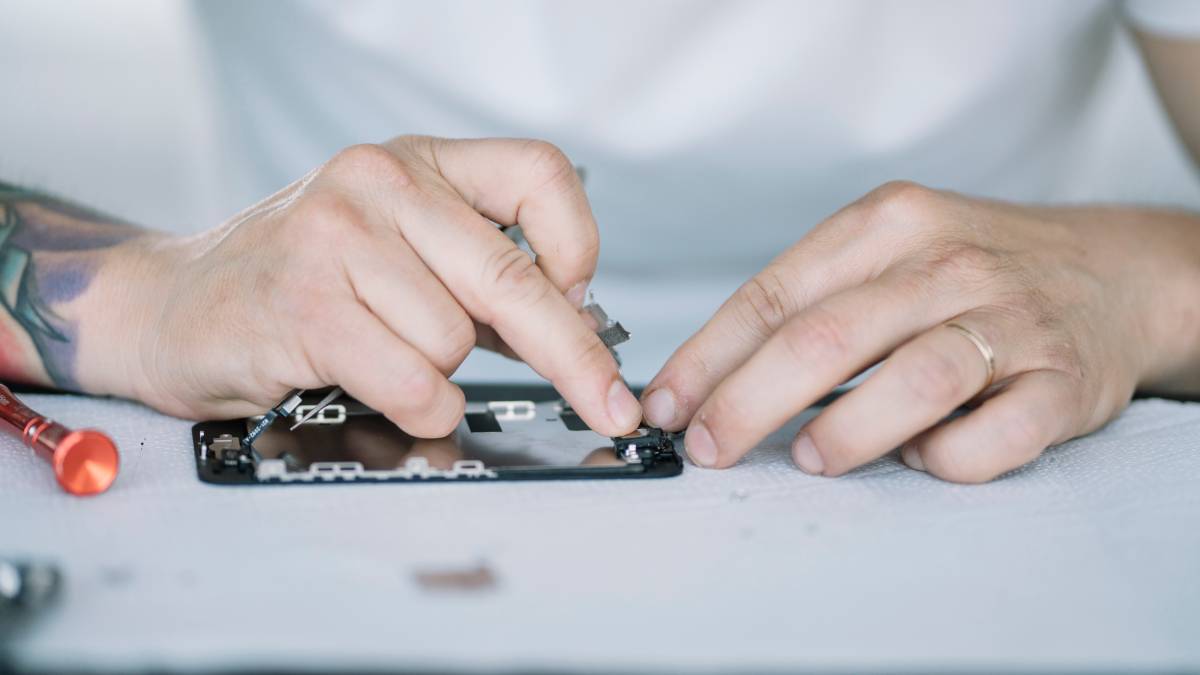 A close-up of a technician repairing an iPhone screen with precision tools, ensuring the delicate components are reassembled correctly. 