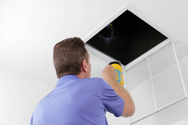 Inspecting HVAC during monthly home maintenance