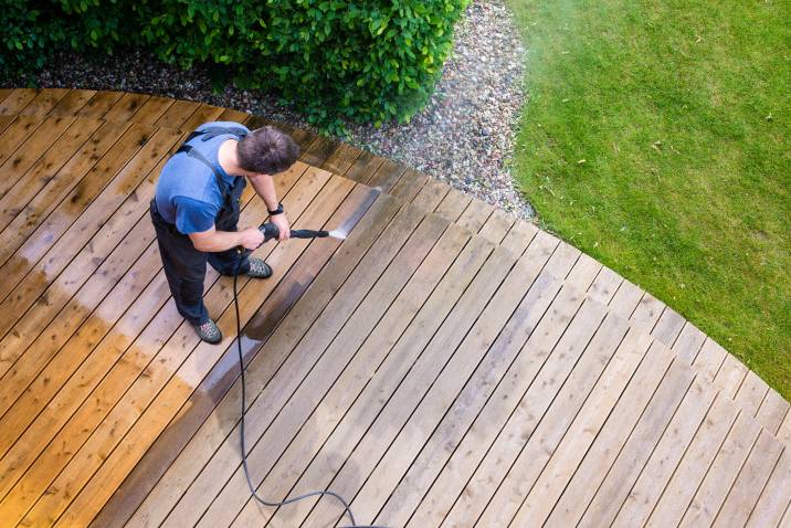 Pressure washing deck during summer maintenance