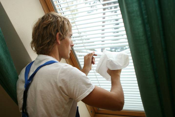 a man showing how to clean Venetian blinds