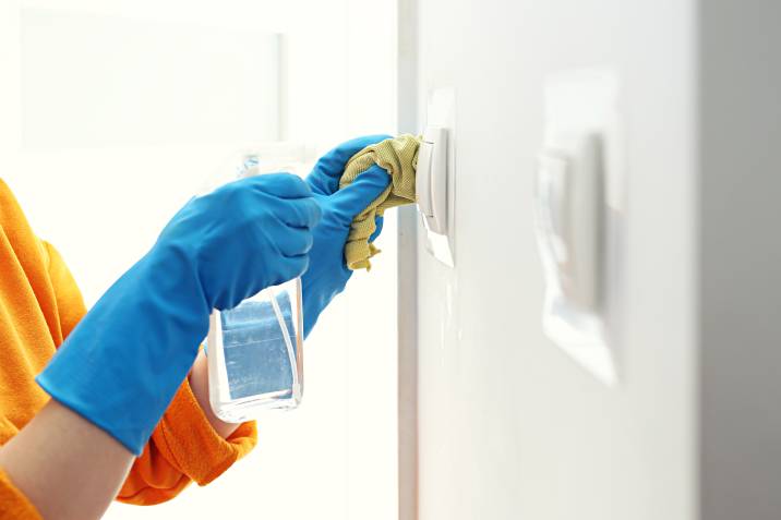 a woman cleaning light switches
