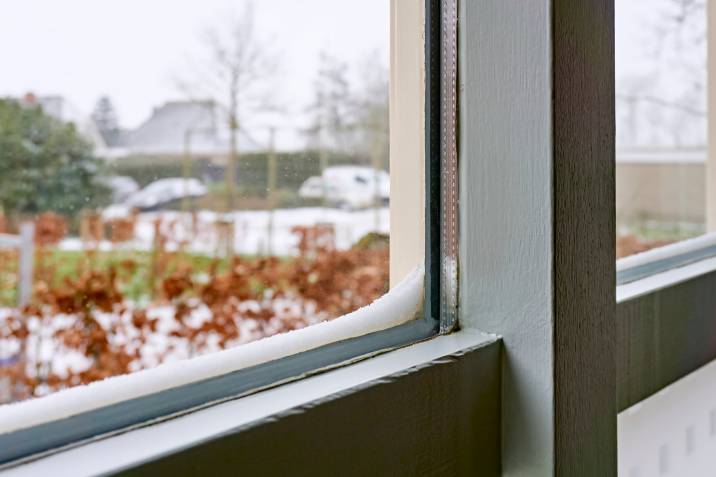 close-up photo of a double pane window with snow