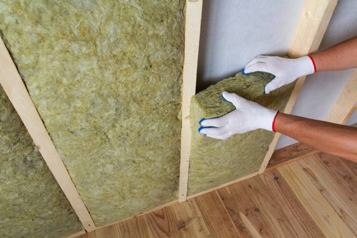a worker using rock wool for insulation