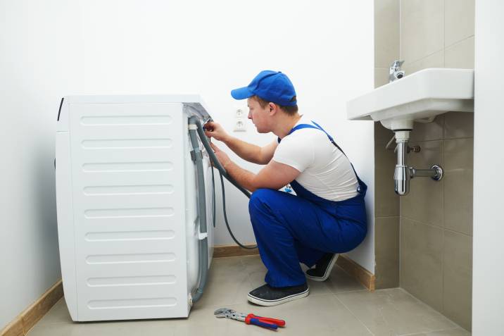 a serviceman installing a washing machine