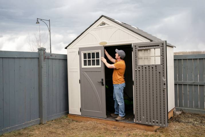 Handyman installing a garden shed