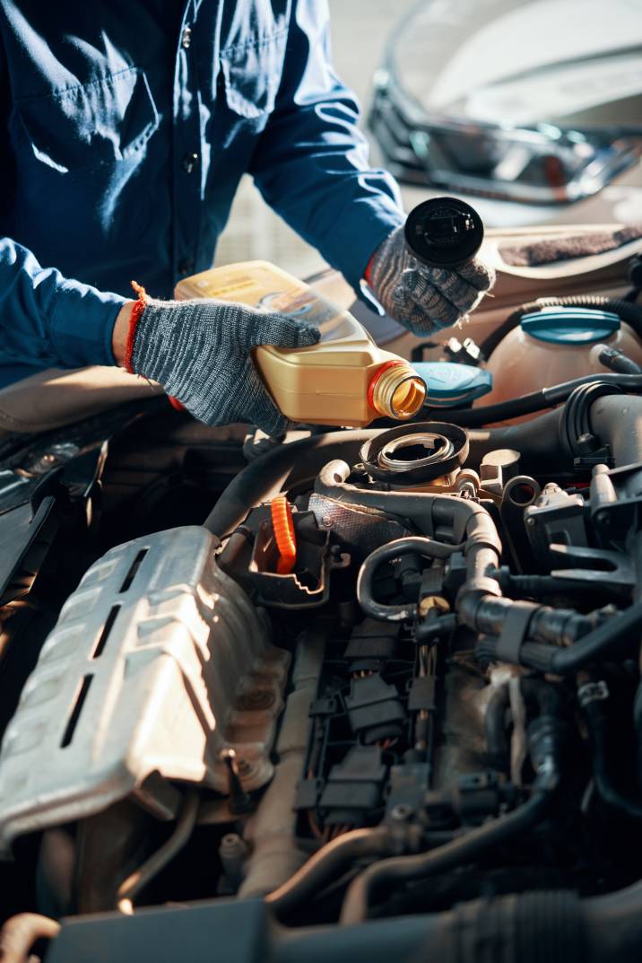 a mechanic changing the oil of a car engine