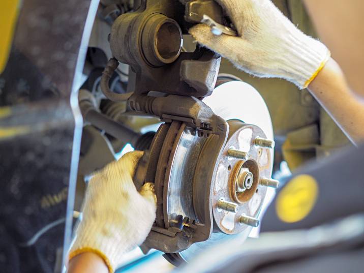 a mechanic performing brake pad replacement