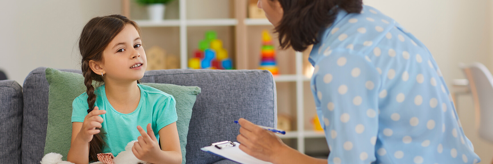 A child sitting in a counseling session, talking to a therapist, with a comforting and supportive environment.