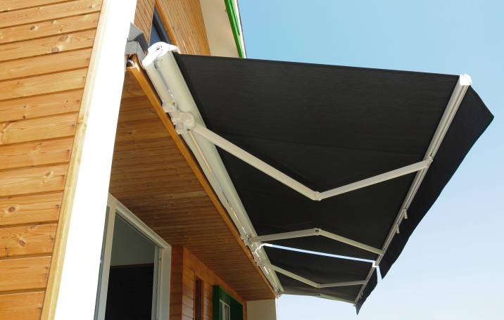 an installed patio awning for sunshade for a modern wooden house