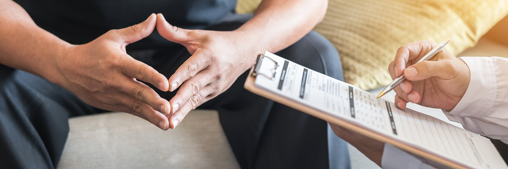 A person sitting on a couch, engaged in a supportive discussion about mental health.