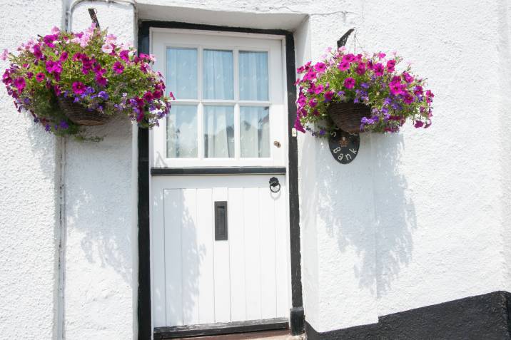 door with hanging plants on each side