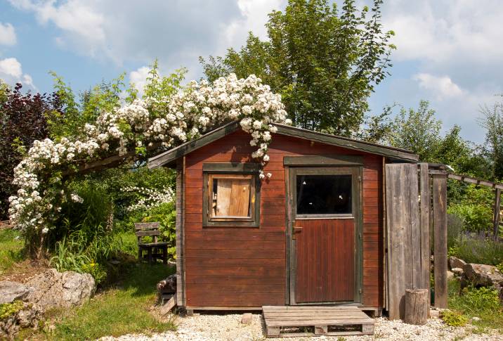 An old wooden shed with a weathered red door