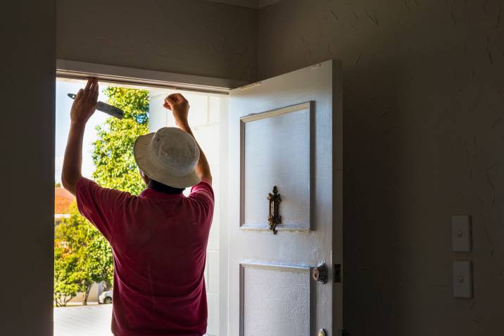 man inspecting their doorframe