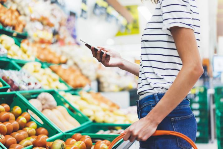 person checking their grocery list on their phone in the supermarket