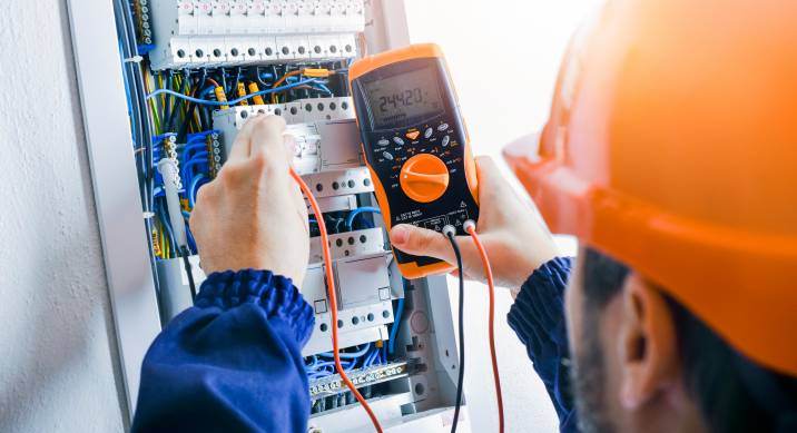 electrician checking a switch board's power rating