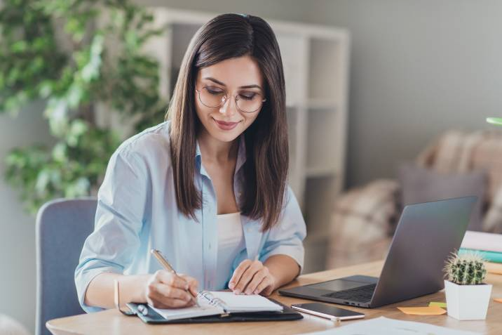 woman writing tasks on her notebook