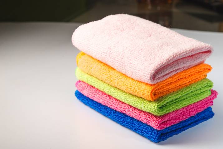 stack of microfibre dusters, colourful cleaning cloths
