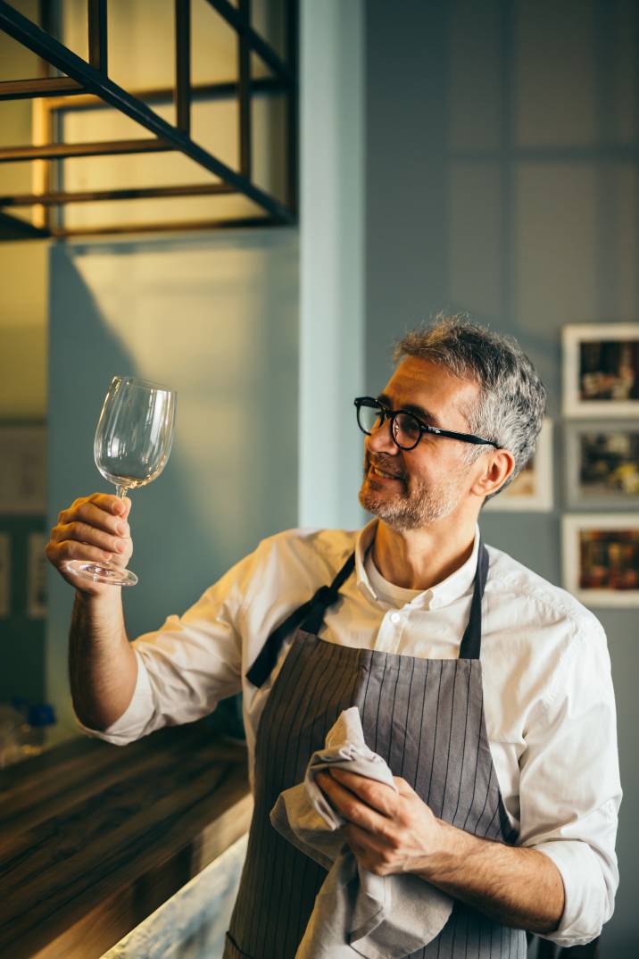 middle-aged man polishing wine glass