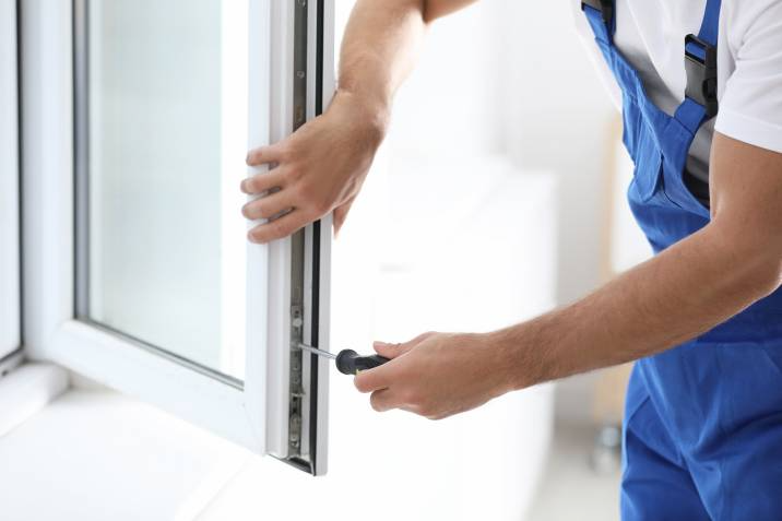 handyman installing a window panel