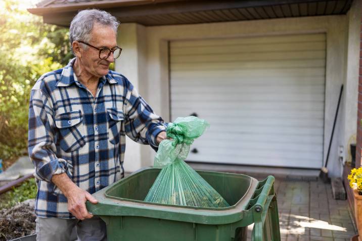 senior man taking out rubbish to avoid house odours