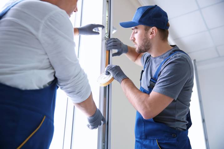 man installing vinyl tape on a window