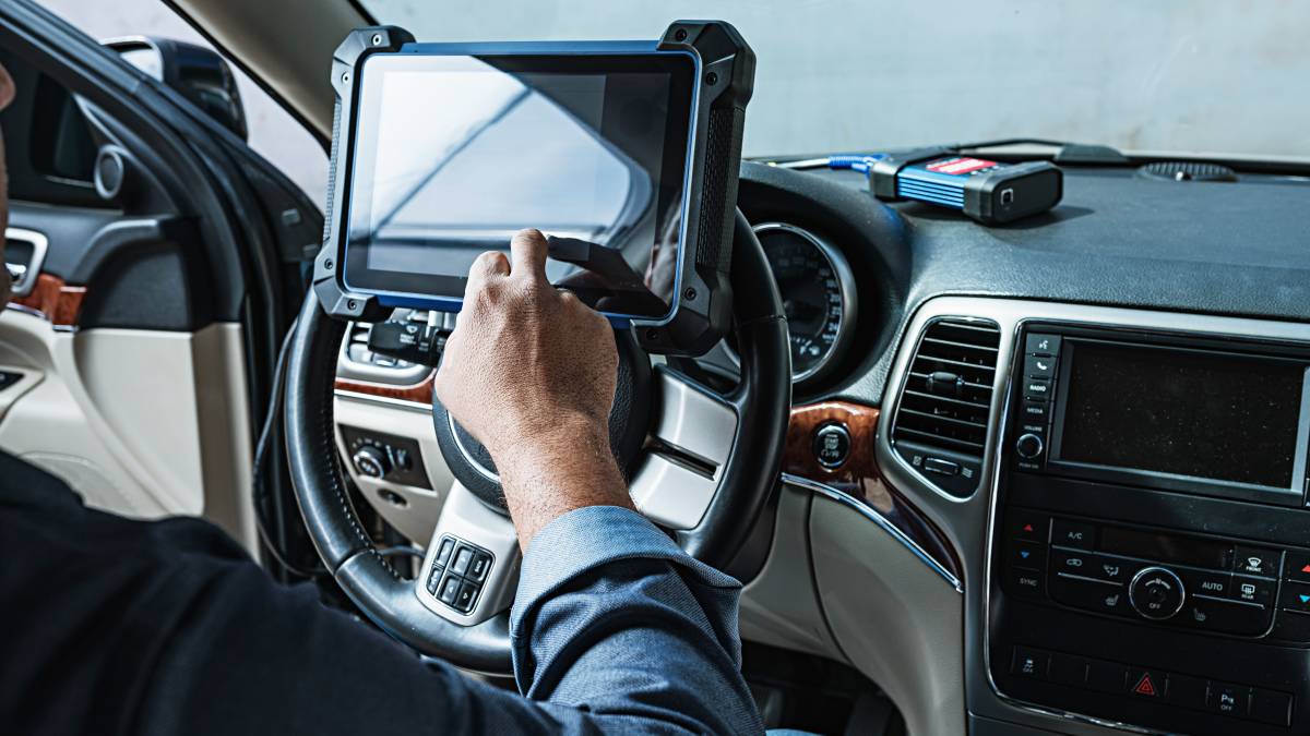 A mechanic performing a car diagnostic test using an advanced scanning tool.