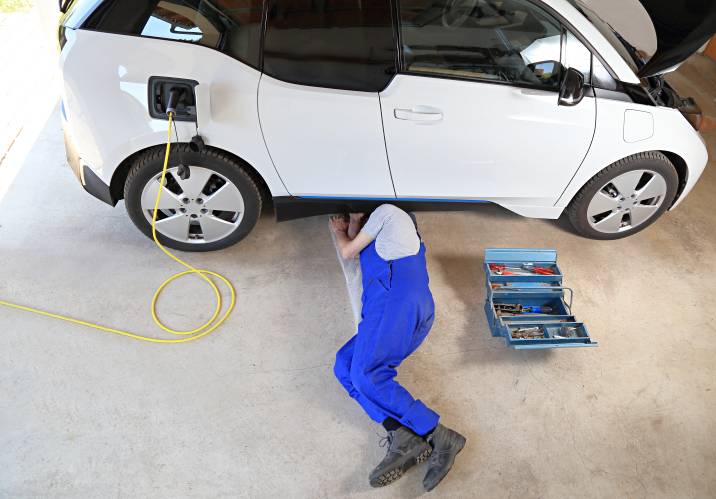 a mechanic servicing an electric car