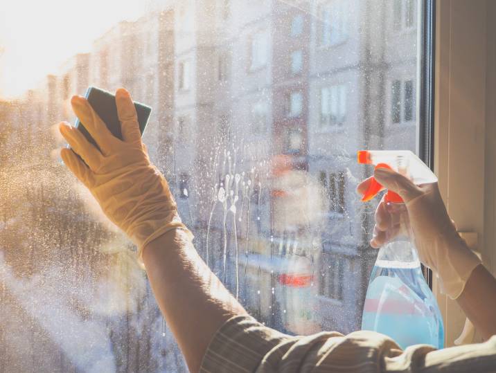 Spraying glass detergent on window