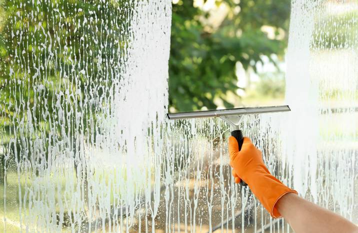 Cleaning window indoors with squeegee