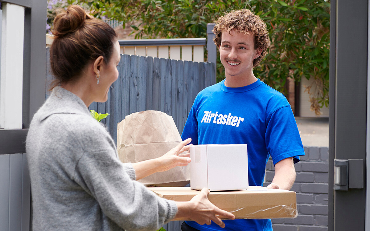 A person receiving a several packages from a courier delivery service.