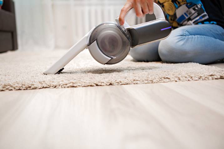 a woman vacuuming a rug