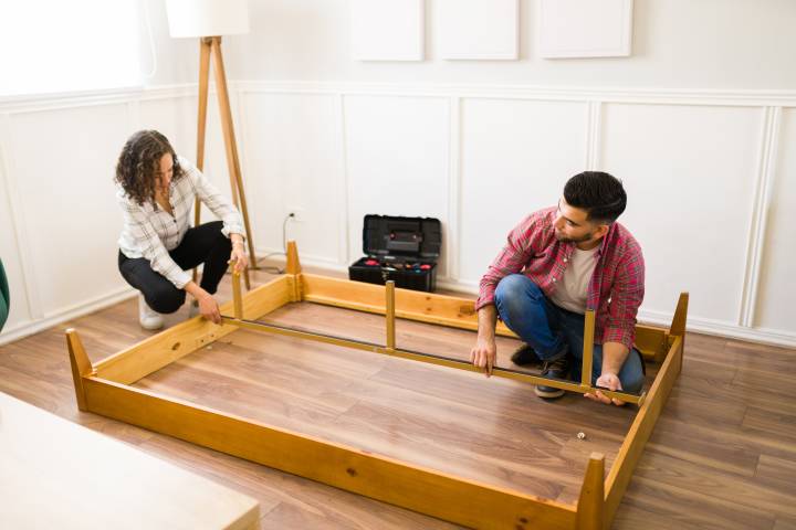 couple removing the main parts of a bed frame