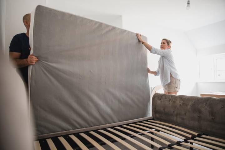 couple removing mattress from the bed frame