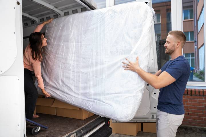 loading a mattress into a moving truck