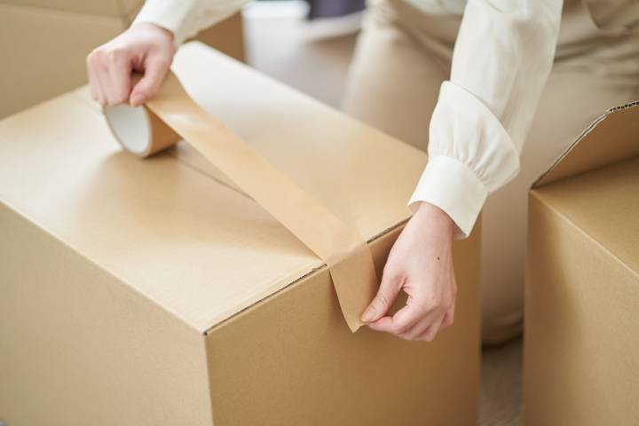 woman sealing her moving boxes properly