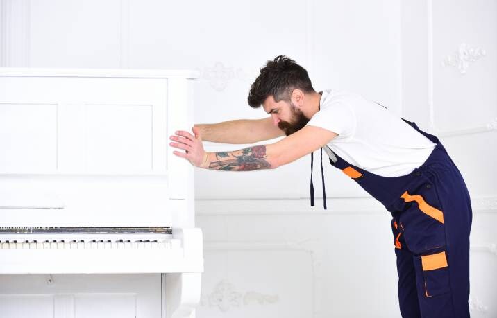 a man pushing a piano