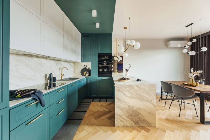 Sage and turquoise apartment colour scheme. Marble kitchen island with gold fixtures and white decorations