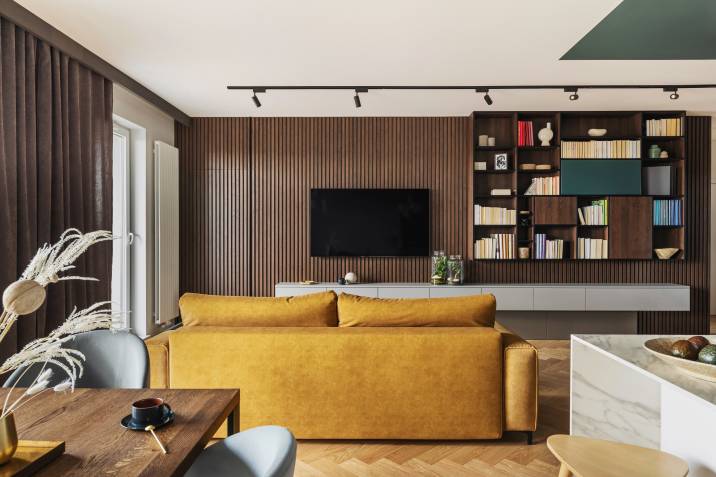 Coffee brown apartment walls and curtain in windows. Vintage living room with yellow sofa and lamella wall with TV and bookcase