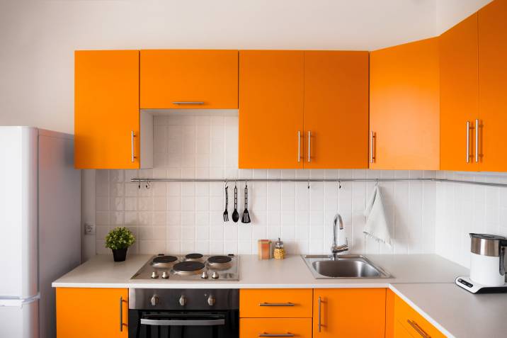 Kitchen with orange cabinets and white wall