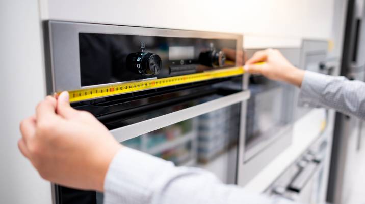 person measuring kitchen appliances