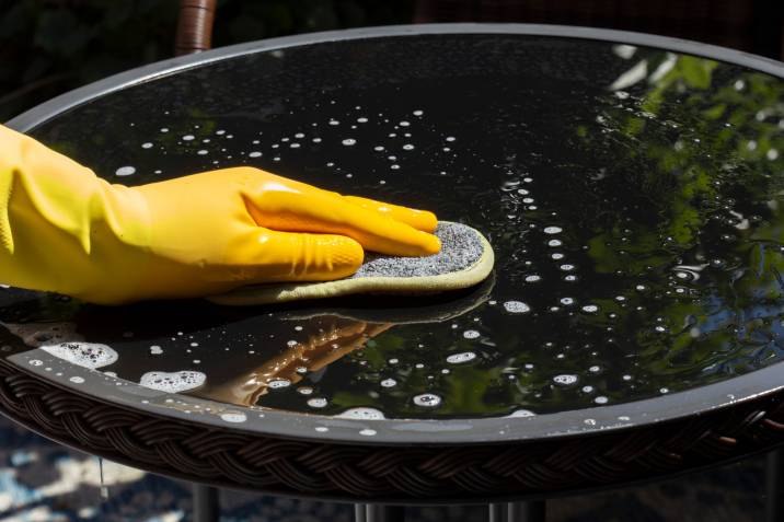 person cleaning outdoor table