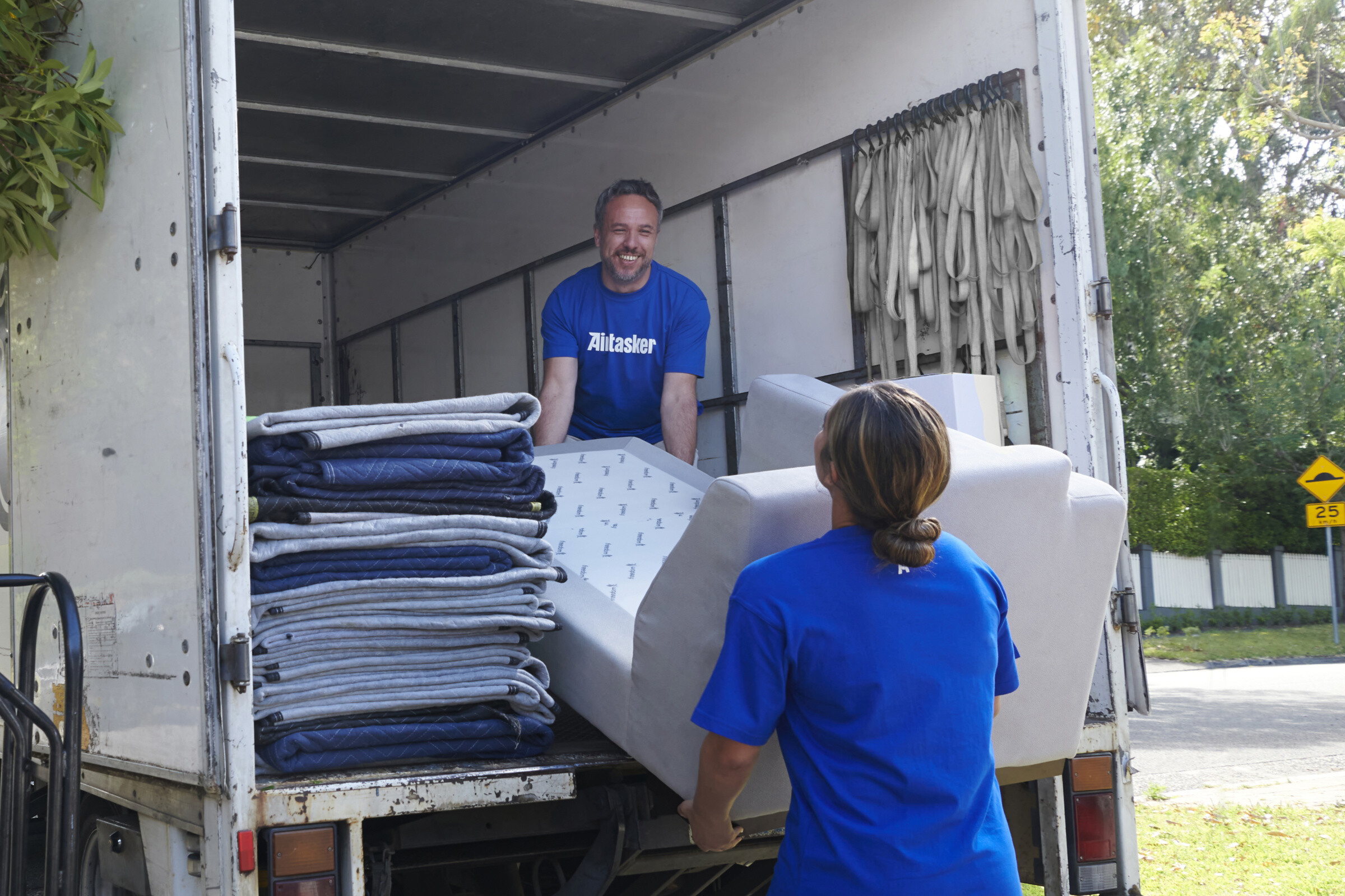 A group of movers carrying furniture out of a house, ready for removal.