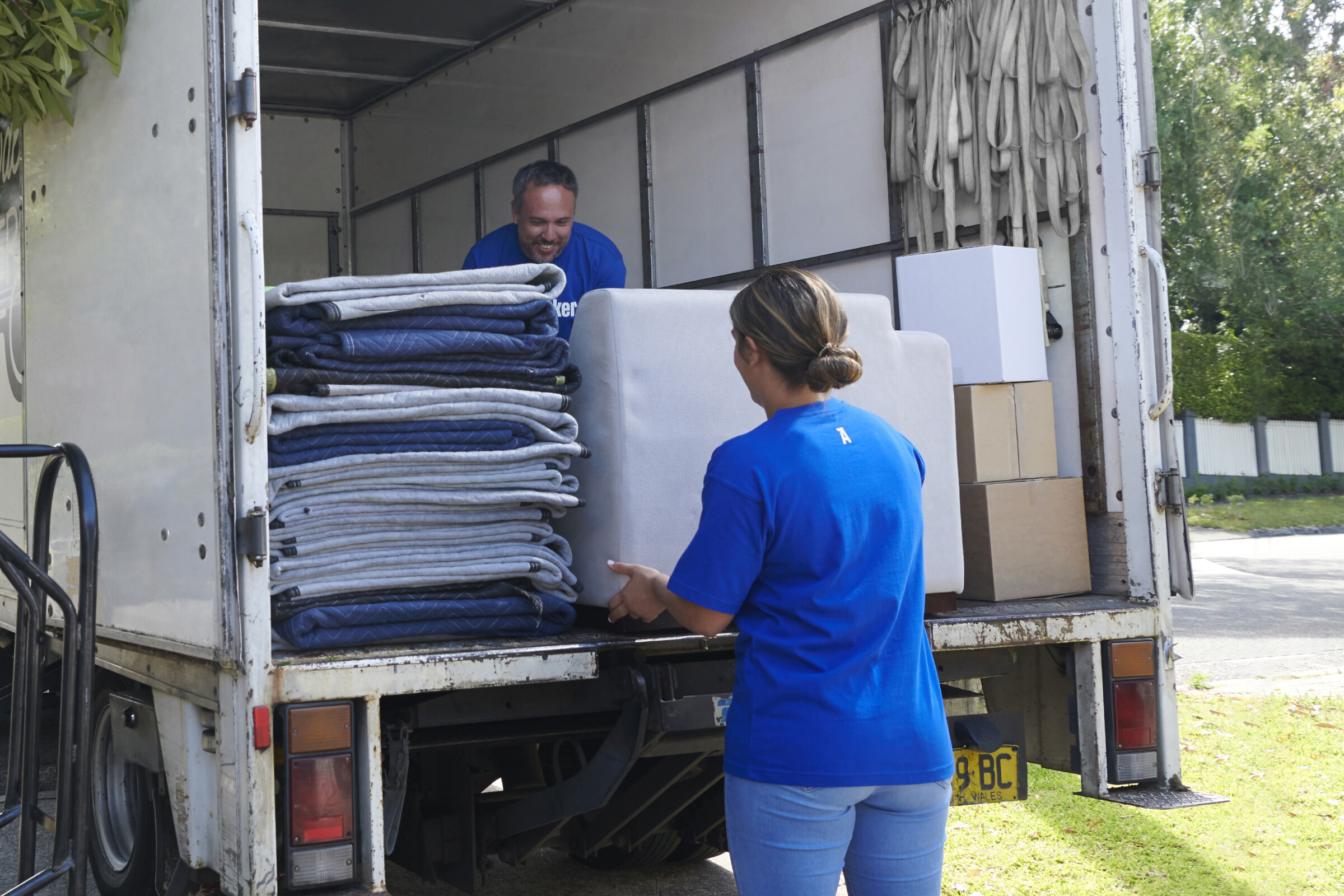 A group of people helping with a move, carrying boxes and furniture, working together to make the process easier.