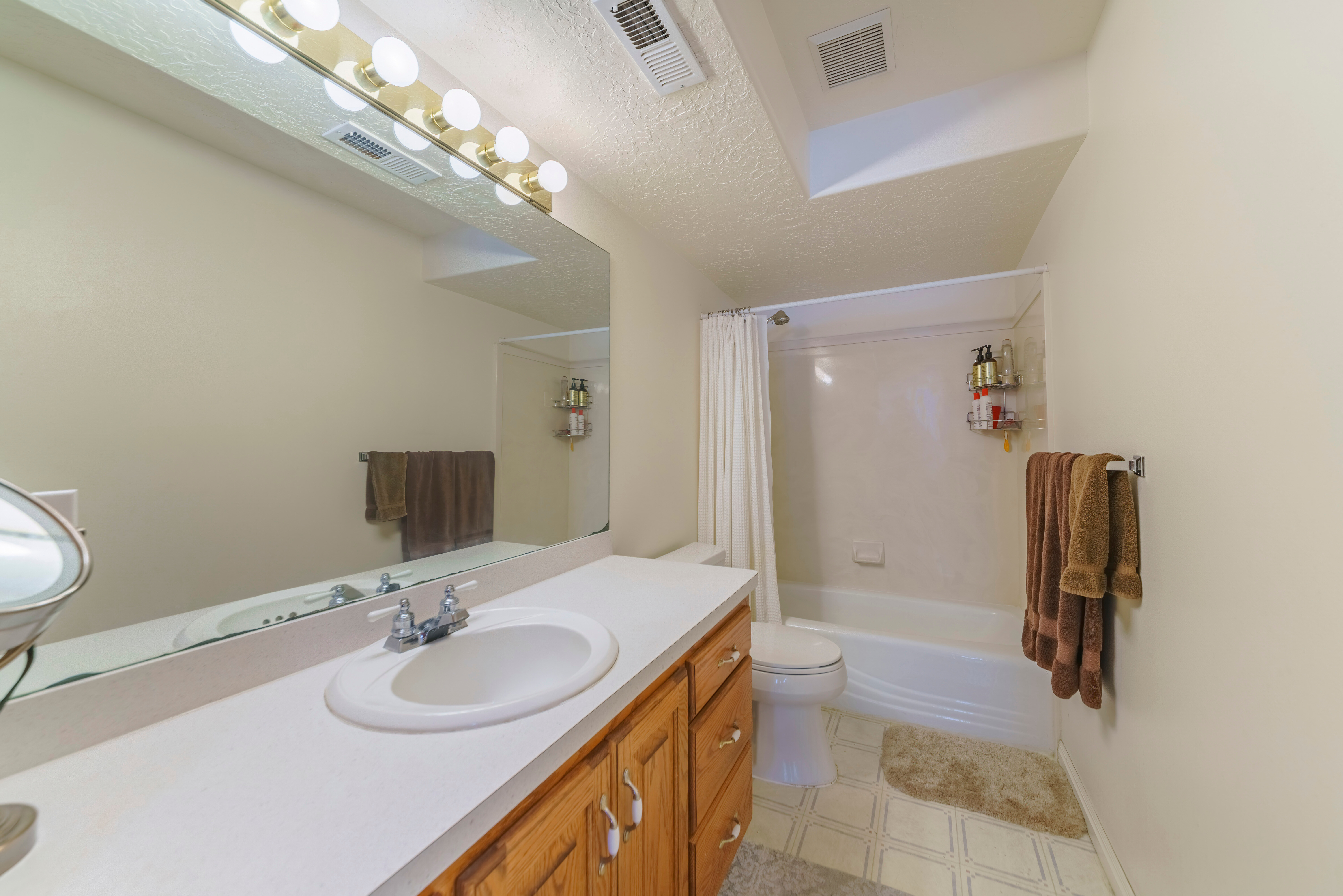clean bathroom vanity sink with wall lighting