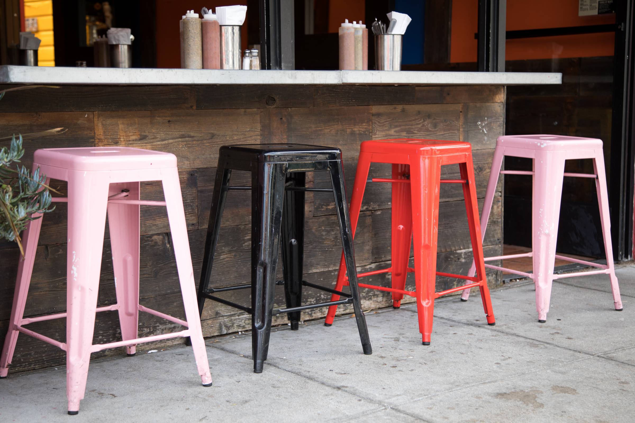 pink and red covered outdoor kitchen bar stools